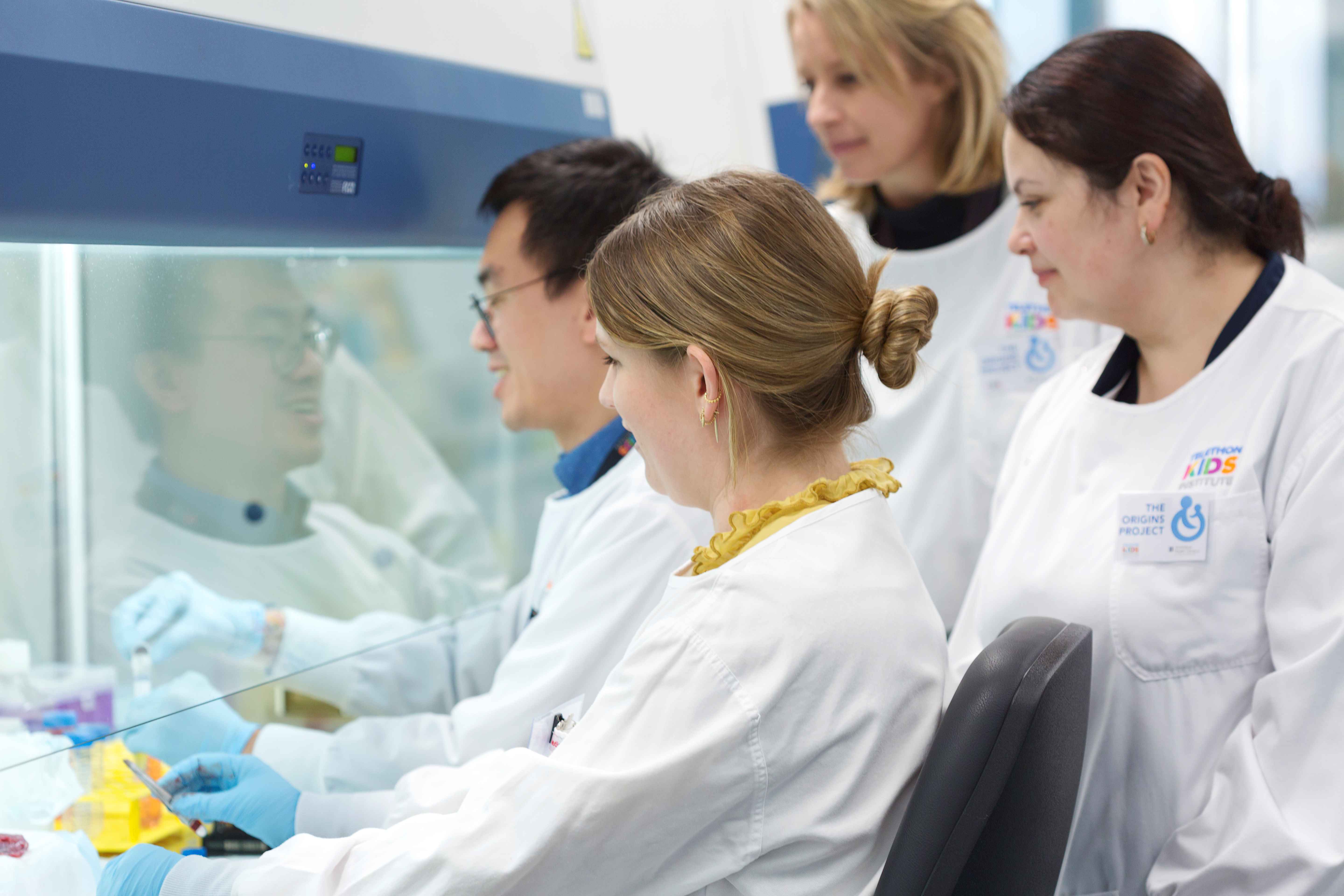 Researchers huddled together in a lab around a specimen